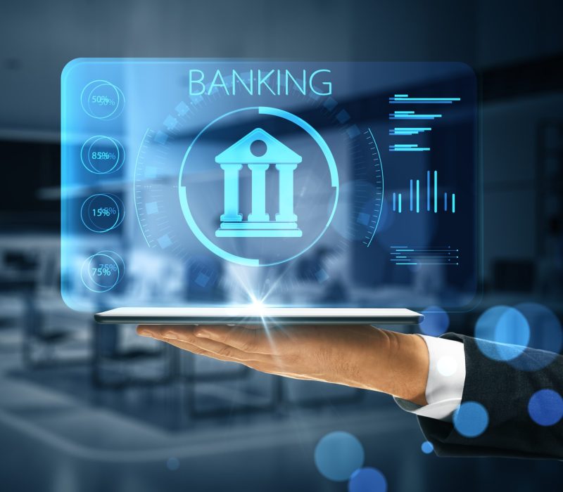 Online banking application concept with digital bank building sign with indicators on virtual projection from digital tablet on man hand